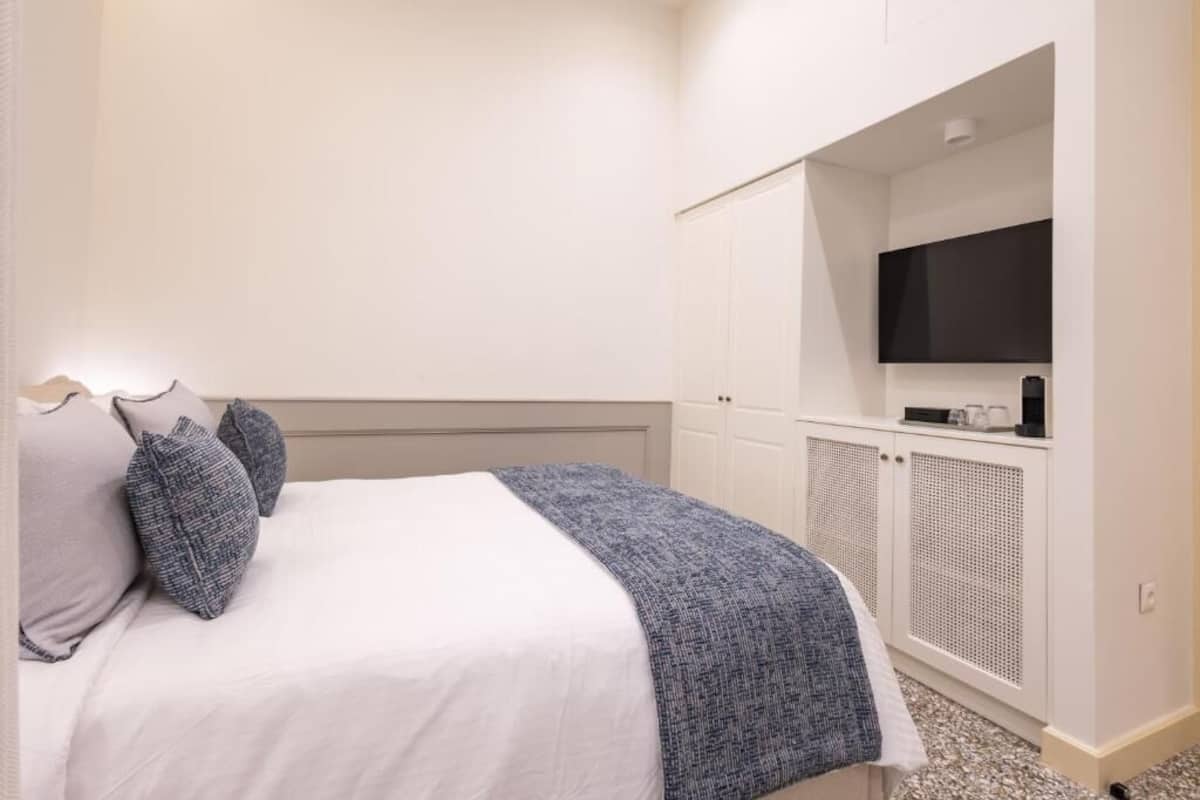 A hotel room with a bed, a television, and a wardrobe.
