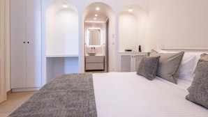 Une chambre à coucher avec un grand lit, une armoire, une coiffeuse avec un miroir et un petit meuble.
