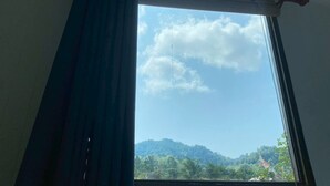A window with a view of a mountain landscape and a temple. - Aonang green tree (Krabi)