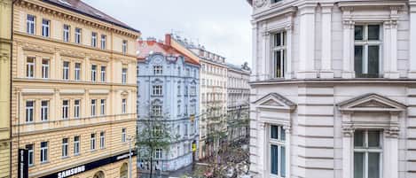 A street view with buildings featuring classical architecture, a Samsung store, and a crosswalk.