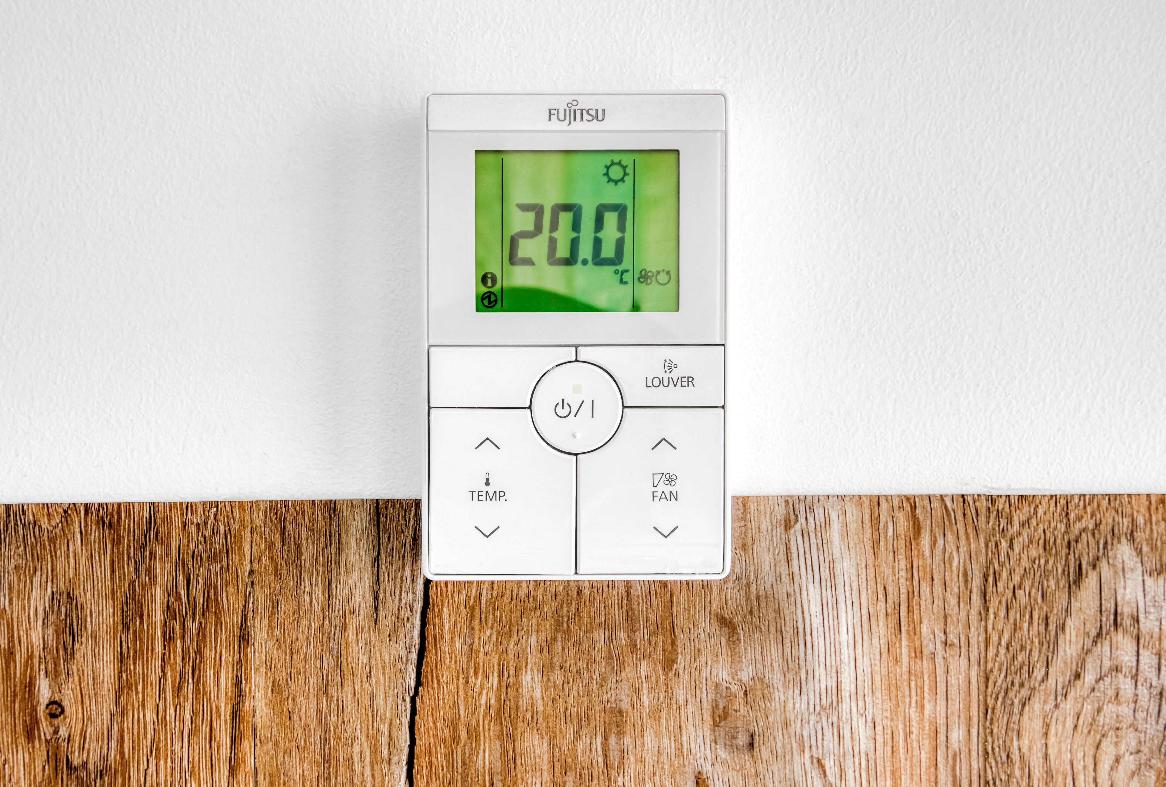 Un termostato bianco con display digitale che mostra 20,0°C, un pulsante di accensione, un pulsante per regolare la temperatura e un pulsante per regolare la velocità della ventola.