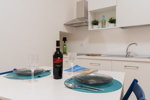 A dining table with a wine bottle, glasses, and a placemat.