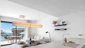Une chambre d’hôtel moderne dotée d’un balcon, d’un coin repas et d’une cuisine.