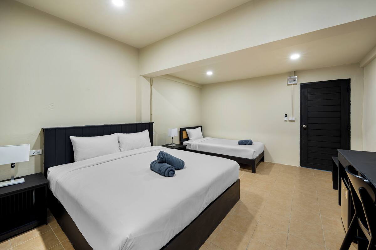 Una habitación de hotel con dos camas, un escritorio y una silla.