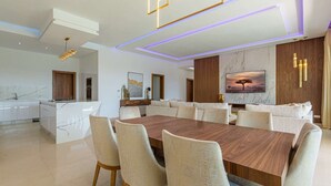 A modern dining area with a large wooden table and beige upholstered chairs. - Superb Marrakech villa with heated pool (Marrakech)