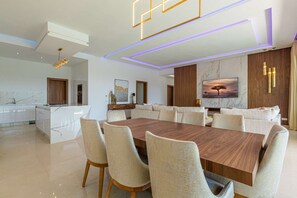 A modern dining area with a large wooden table and beige upholstered chairs. - Superb Marrakech villa with heated pool (Marrakech)