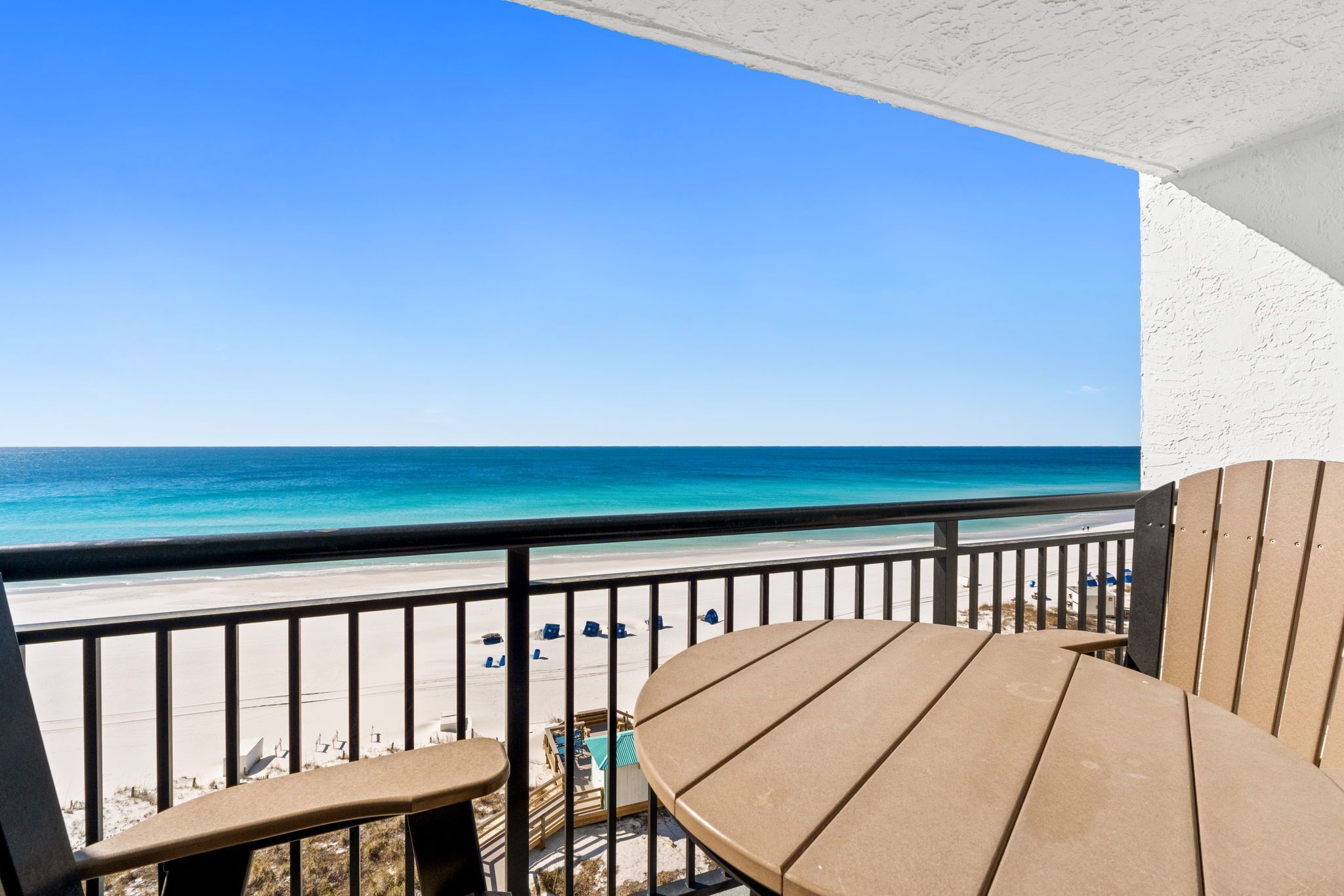 A balcony with a view of the beach and ocean.