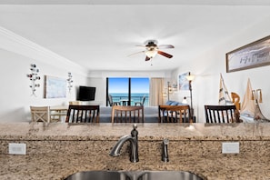 A modern kitchen with granite countertops, a built-in sink, and a ceiling fan. - SunDestin Gulf-View 1BR Condo | 8th Floor, Indoor/Outdoor Pools, Private Beach Access (Destin)