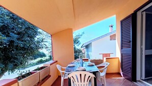 Ein Balkon mit Esstisch, Stühlen und Blick auf die Umgebung.