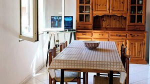 Ein Essbereich mit Tisch, Stühlen, einem Holzschrank und einem Fenster mit Blick.