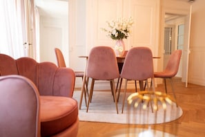 Un coin repas avec une table ronde, six chaises et un vase de fleurs.