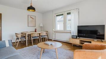 Un salon moderne comprenant un téléviseur, un canapé et un coin repas.