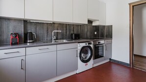 Una cocina moderna con lavadora, cafetera y microondas.
