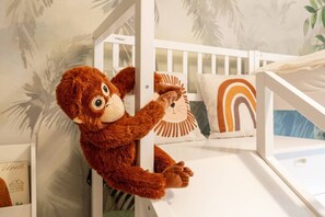 A white bunk bed with a plush monkey toy hanging from the side rail. - Family 3-BR with kids` slide · near main station (Zürich)