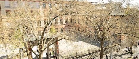 A historic building with a courtyard, stone steps, and bare trees.