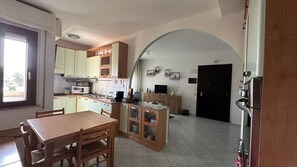 Eine kompakte Küche mit Essbereich, mit einem Holztisch und Stühlen, einem eingebauten Backofen und einer Mikrowelle.