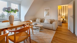 Un appartement moderne de style « loft », comprenant un coin repas, un canapé, une petite table et une vue sur l’extérieur.