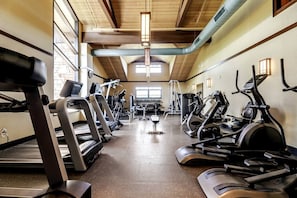 A gym with treadmills, elliptical machines, and weight equipment.