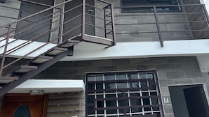 Un edificio moderno con una escalera que conduce a un balcón, un ventanal grande y una puerta con el número 14.