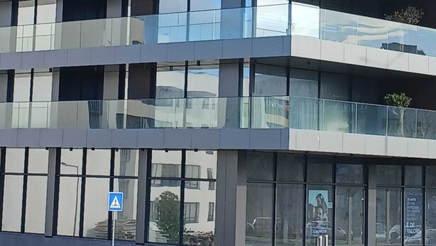 Un moderno edificio a più piani con ampie finestre e balconi.