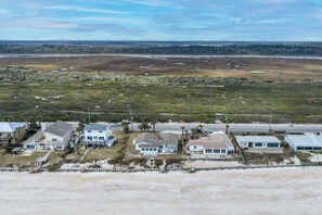 Una zona residenziale sulla costa, con case, una spiaggia e una strada.
