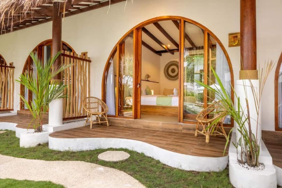 A room with a bed, a window, and a wooden ceiling.