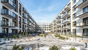 A modern apartment complex with multiple balconies, a central courtyard, and a clear sky. - RentPlanet - Apartament Przemysłowa (Katowice)