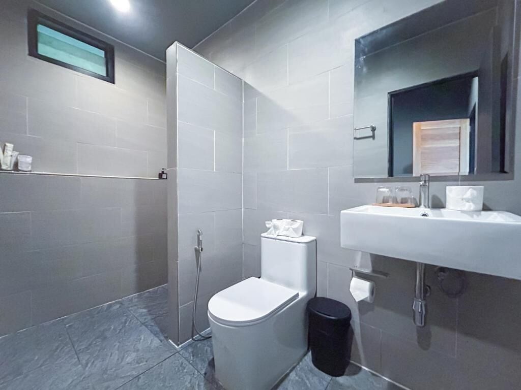 Een moderne badkamer met toilet, hygiëneschuimer en wastafel.