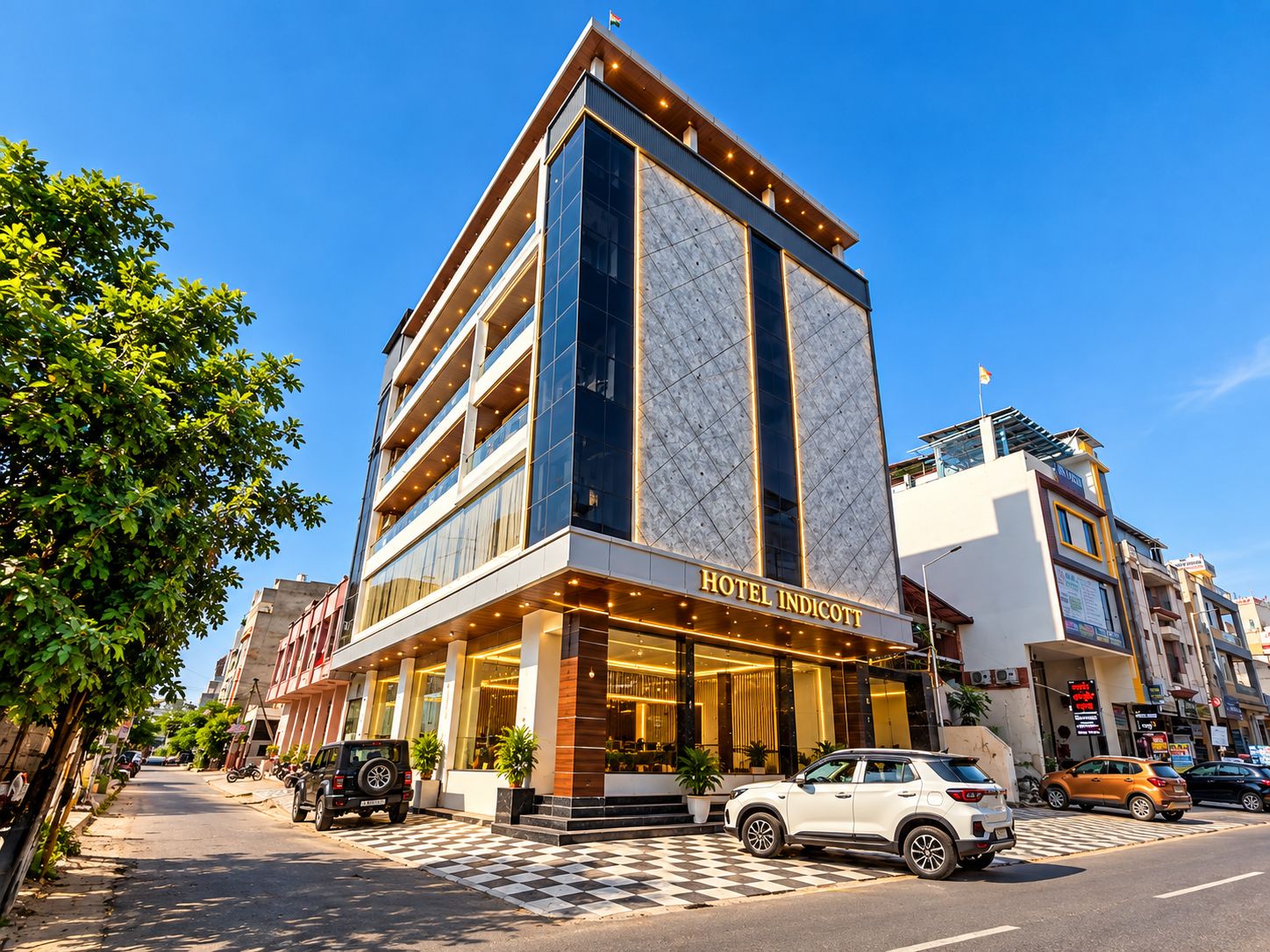 A modern hotel with a prominent entrance, multiple floors, and a clear sky.