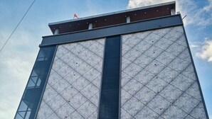 Un bâtiment moderne sur lequel on peut voir une enseigne bien visible indiquant « HÔTEL INDICOTT ».