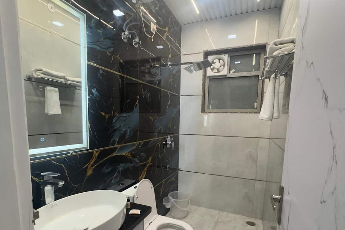 Ein kleines Badezimmer mit einem weißen Waschbecken, einer Toilette und einem Spiegel.