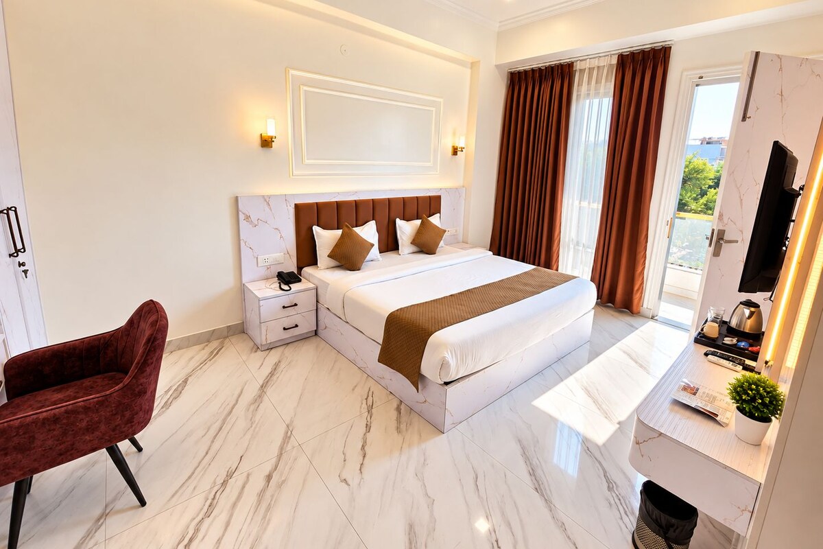 Ein modernes Hotelzimmer mit einem großen Bett, einem Schreibtisch mit Kaffeemaschine und Blick auf Grünflächen.