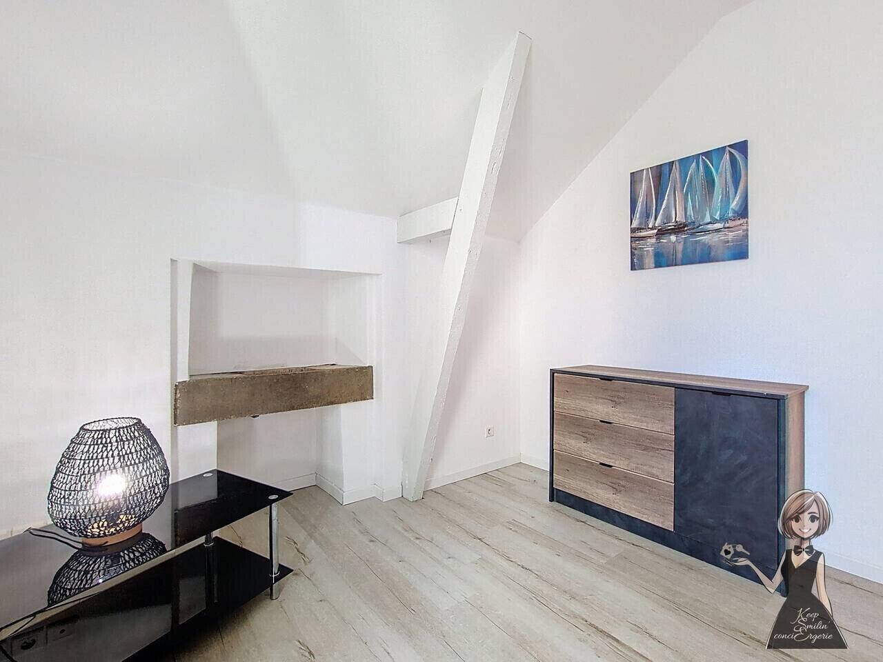 Une pièce moderne avec un plafond en pente, un banc en bois, une cheminée et un tableau représentant des voiliers.