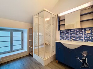 A bathroom with a glass shower enclosure, a vanity with a blue tiled backsplash, and a window with a view of the outside. - L’Écume Pyrénéenne, Ambiance Océan près de Lourdes (Coarraze)