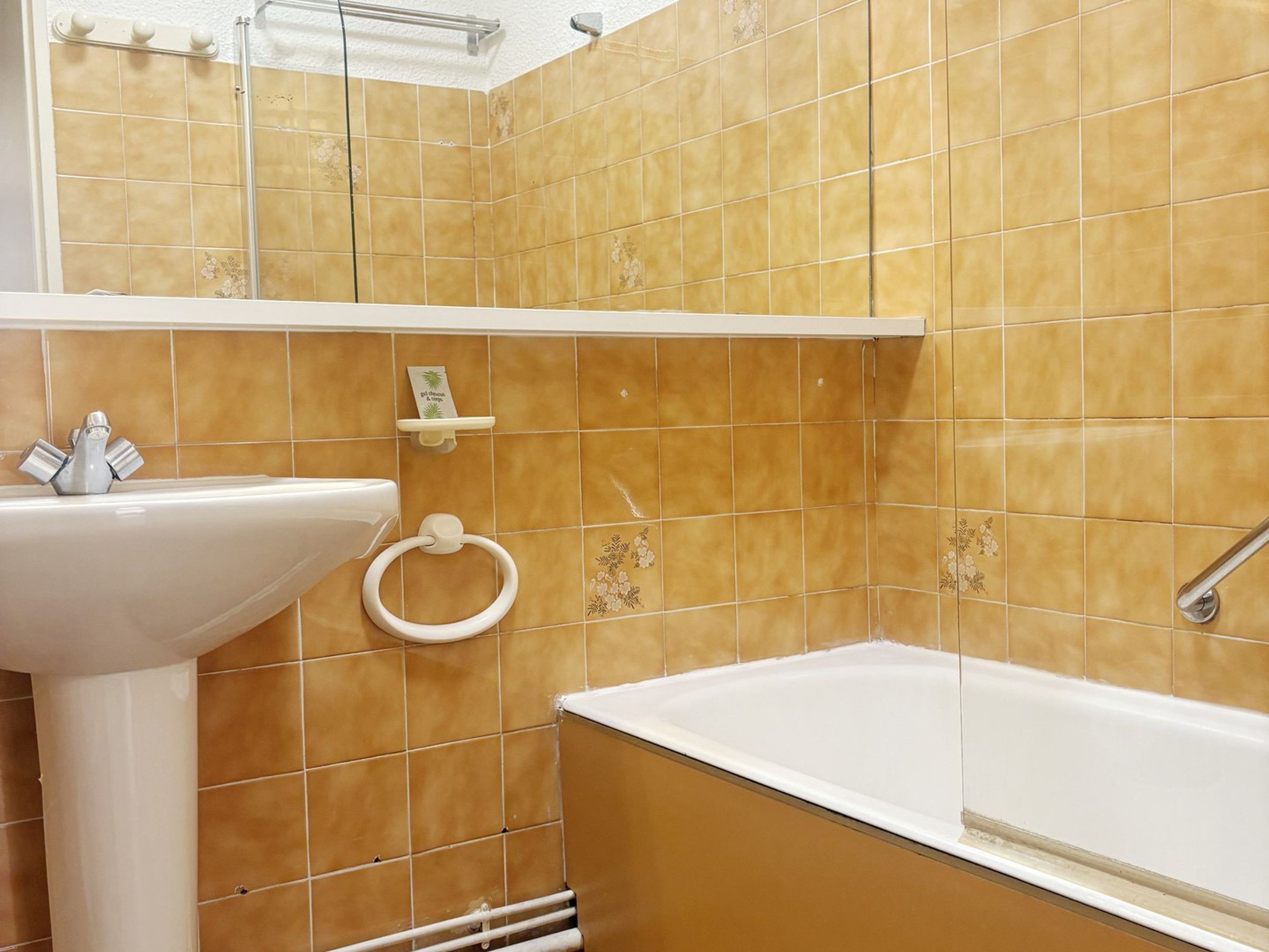 Et badeværelse med en hvid vask, toilet og badekar.