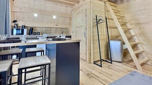 Een moderne keuken met houten balken, een bar en een trap.