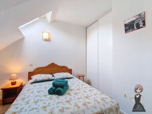 A bedroom with a bed, a nightstand, a lamp, a wall-mounted light, and a framed picture. - Le Refuge, Cocon pour 8 avec Spa & Piscine chauf. (Cauterets)
