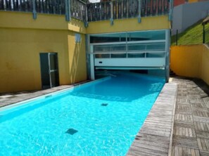 A swimming pool with a wooden deck and a metal fence. - Le Refuge, Cocon pour 8 avec Spa & Piscine chauf. (Cauterets)