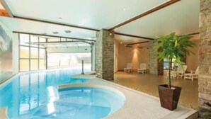 An indoor swimming pool with a view of the outdoors, stone walls, and a potted plant. - Le Refuge, Cocon pour 8 avec Spa & Piscine chauf. (Cauterets)