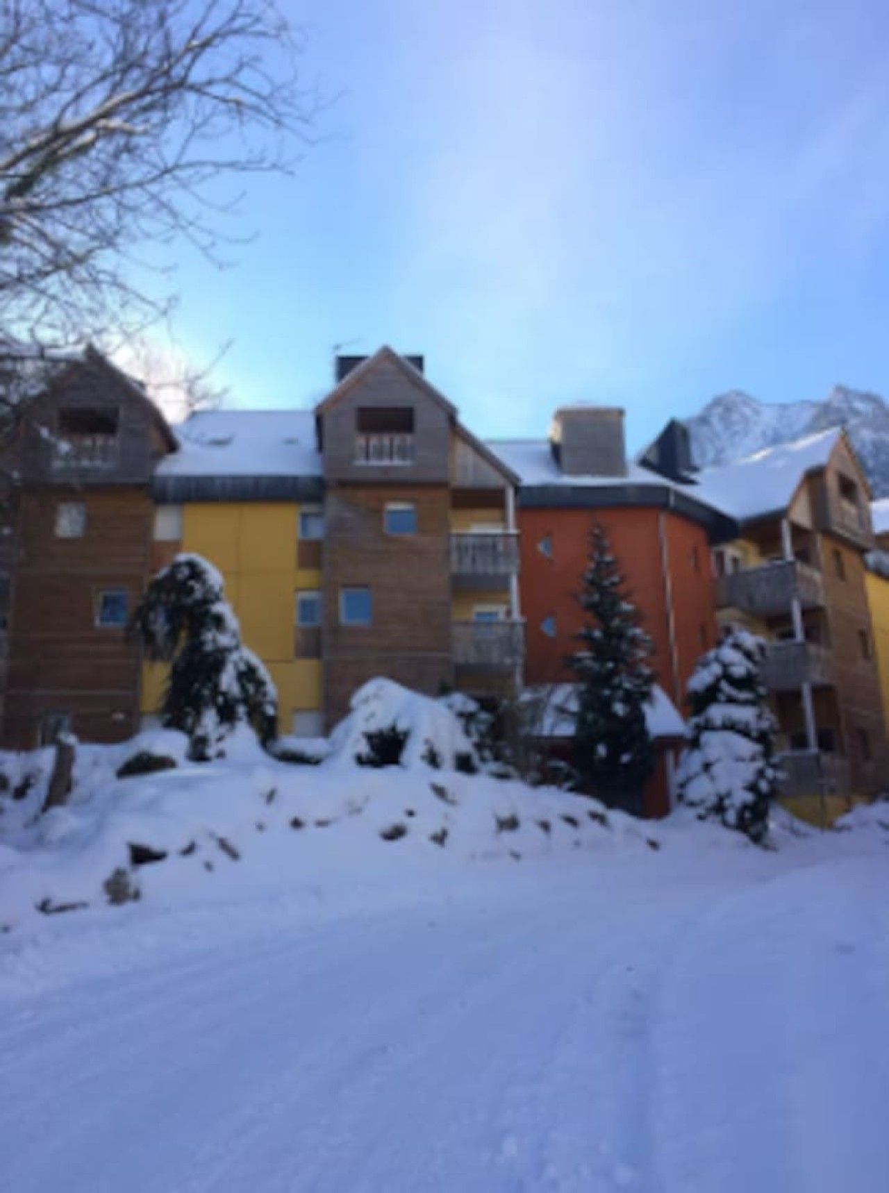 Ein mehrstöckiges Gebäude mit verschneitem Untergrund und blauem Himmel.