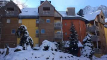 Ein mehrstöckiges Gebäude mit verschneitem Untergrund und blauem Himmel.