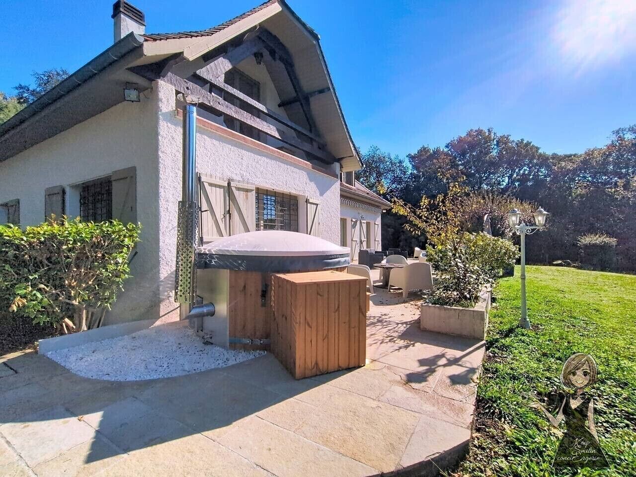A house with a patio area, a wooden bench, and a small garden.