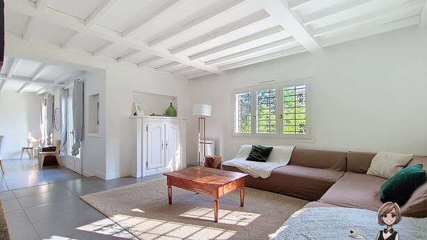 Uma sala de estar ampla com uma mesa de centro de madeira, um sofá marrom e uma janela grande que oferece iluminação natural.
