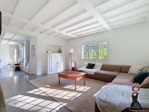 A spacious living area with a wooden coffee table, a brown sofa, and a large window providing natural light. - La Roquetière, Domaine Paradisiaque pour 12 pers. (Ledeuix)