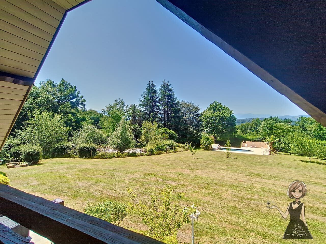A view of a grassy backyard with trees and a pool.