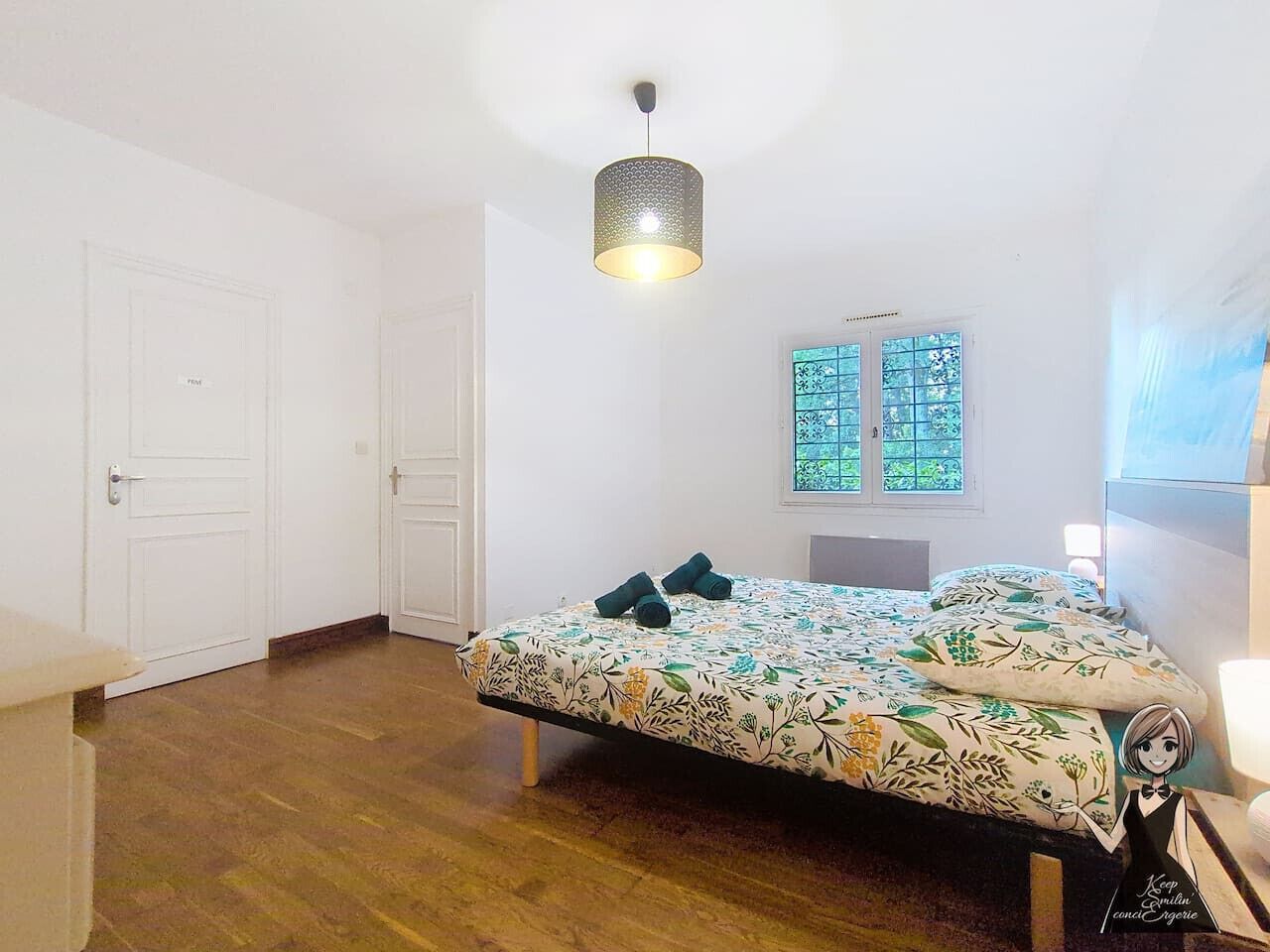 A bedroom with a bed, a window, and a door.