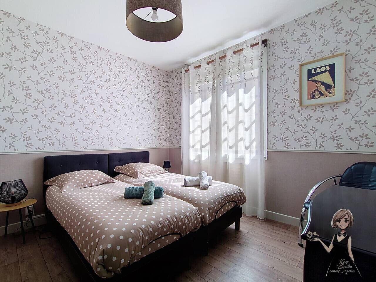 Een slaapkamer met twee bedden, een stoel, een tafel en een poster aan de muur.