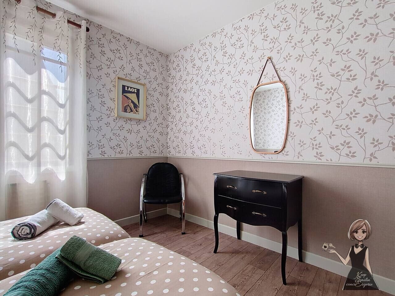 Een slaapkamer met een bed, een stoel, een dressoir, een spiegel en een wand met bloemenbehang.