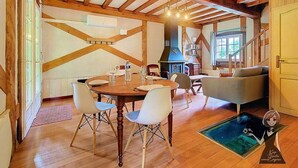 Ein Essbereich mit Holztisch und -stühlen, einer Couch und einem Kamin.