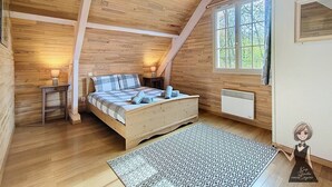 Ein gemütlicher Holzraum mit einem Bett, einem Fenster und einer Heizung.